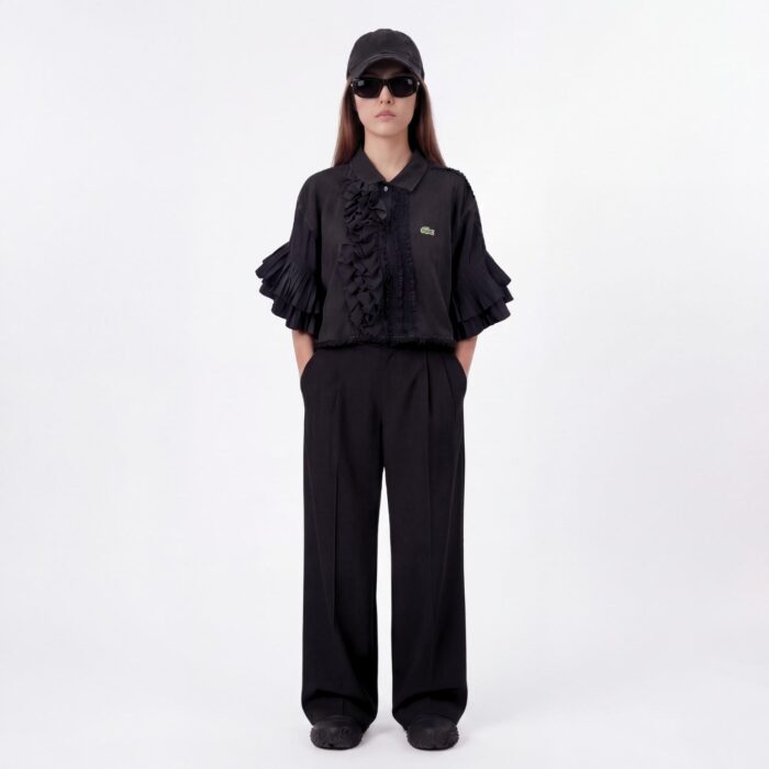 Polo Lacoste vintage col jabot destructuré sur un seul côté porté par une mannequin brune vue de plein pied de face